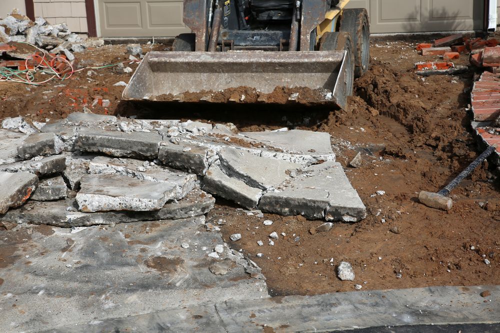 A bulldozer is moving concrete and dirt on a construction site