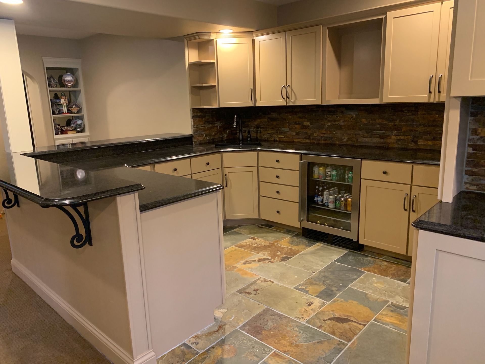 A kitchen with stainless steel appliances , granite counter tops , and tile floors.