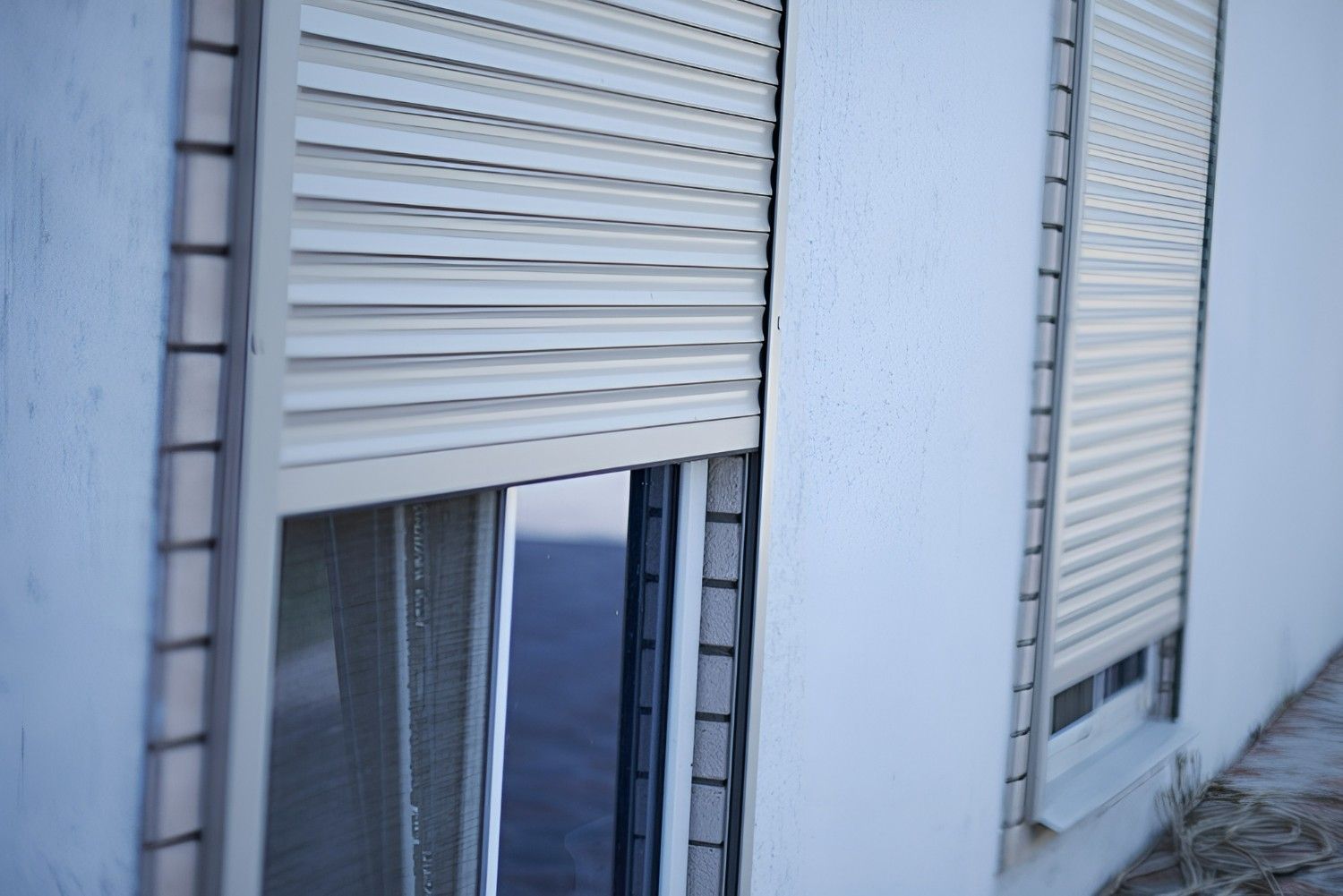 White Building with Partially Open, Beige Rolling Shutter Over a Window — Precision Doors in Berrimah, NT