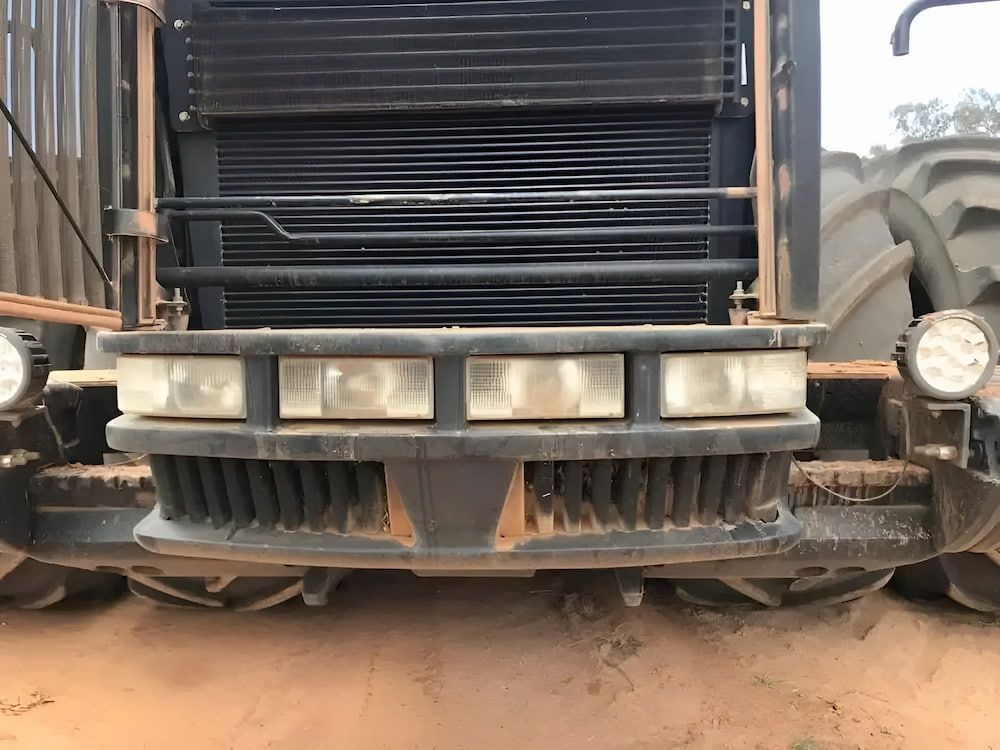 The Front End Of A Tractor Is Covered In Dirt — Ag Auto Spark in Narromine, NSW
