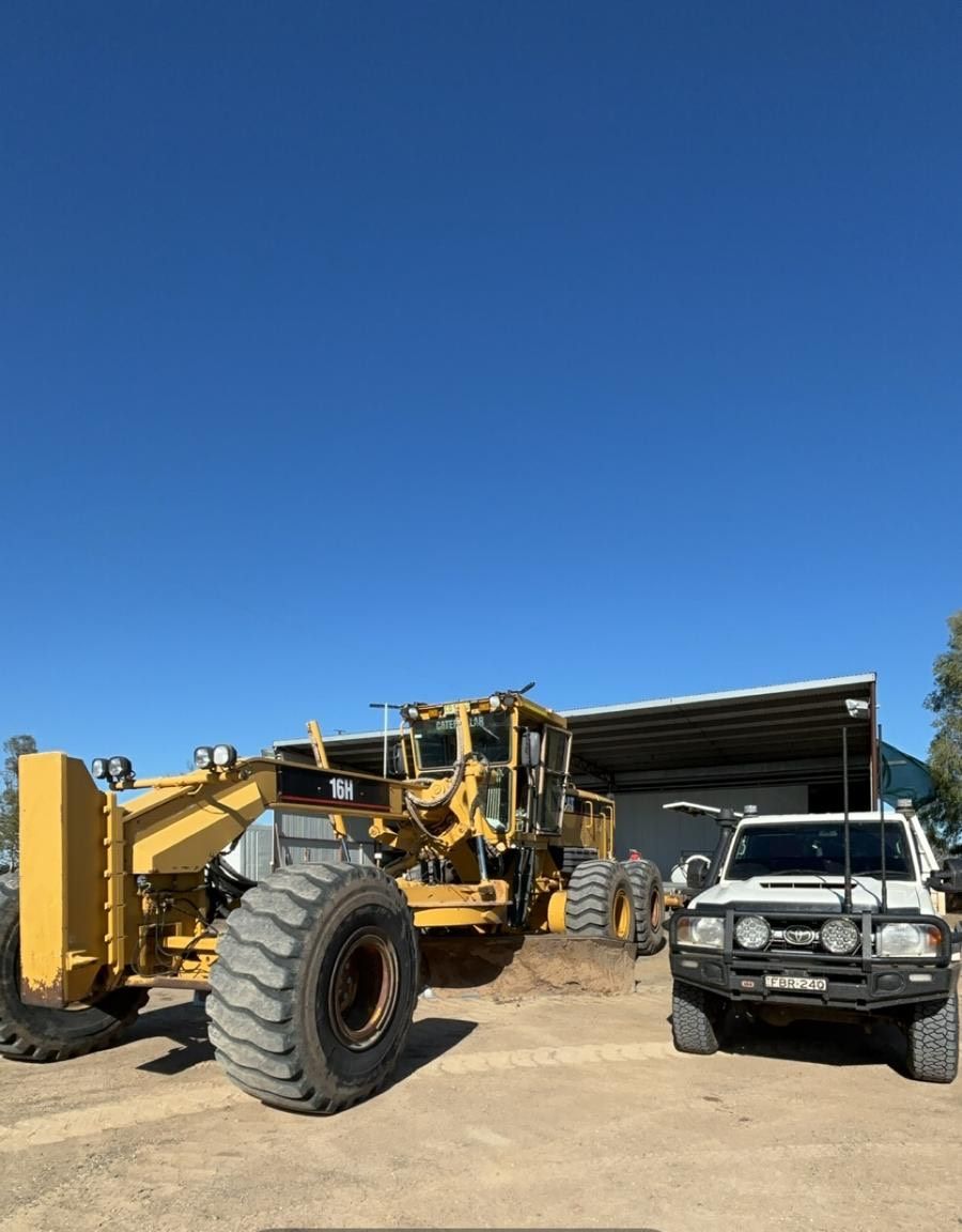 A White Truck Is Parked Next To A Heavy Machine Vehicle — Ag Auto Spark in Narromine, NSW