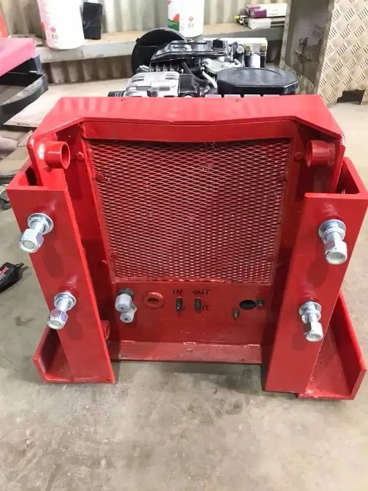 A Red Radiator Is Sitting On The Ground Next To A Tractor Engine — Ag Auto Spark in Narromine, NSW
