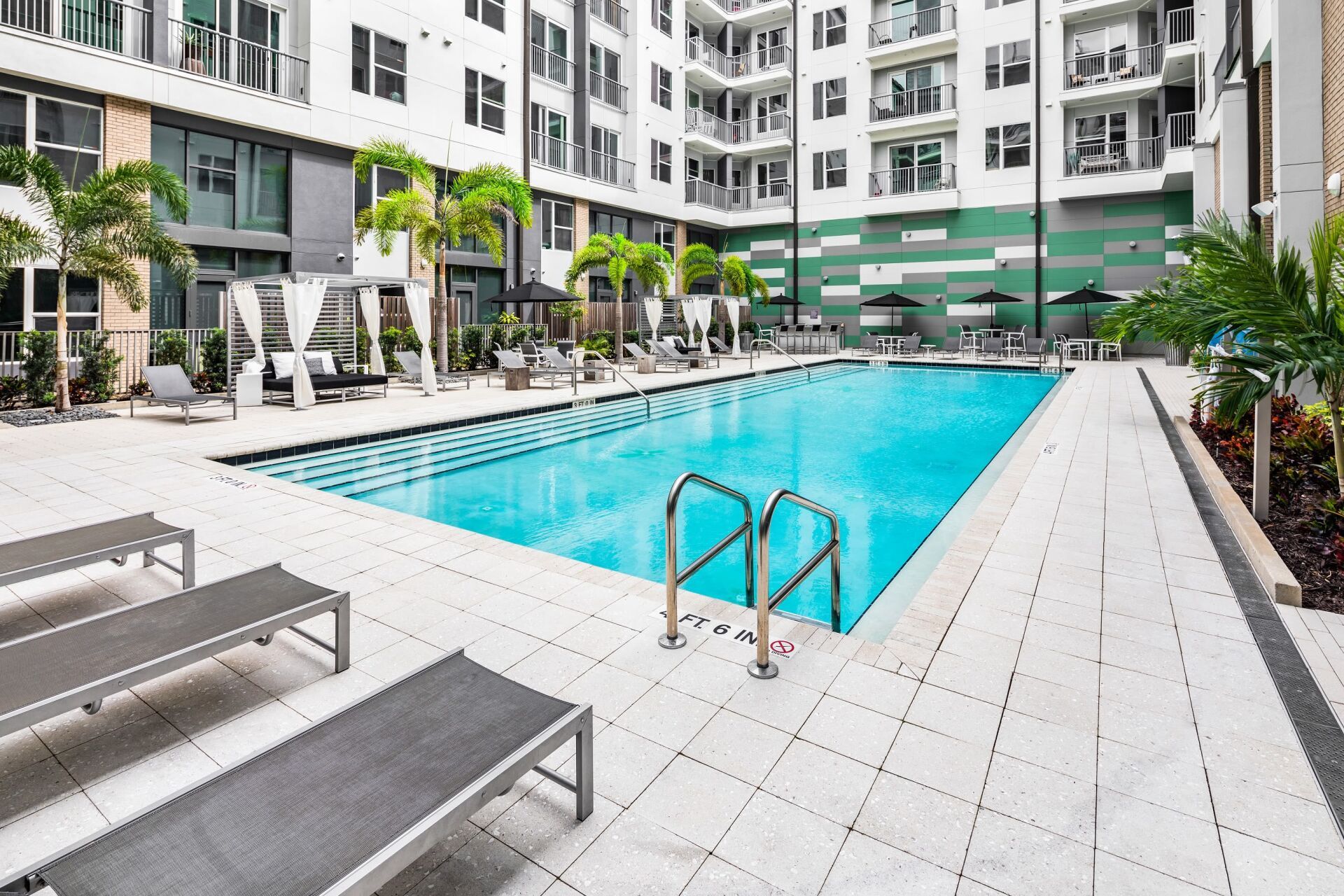 There is a large swimming pool in the middle of a building.