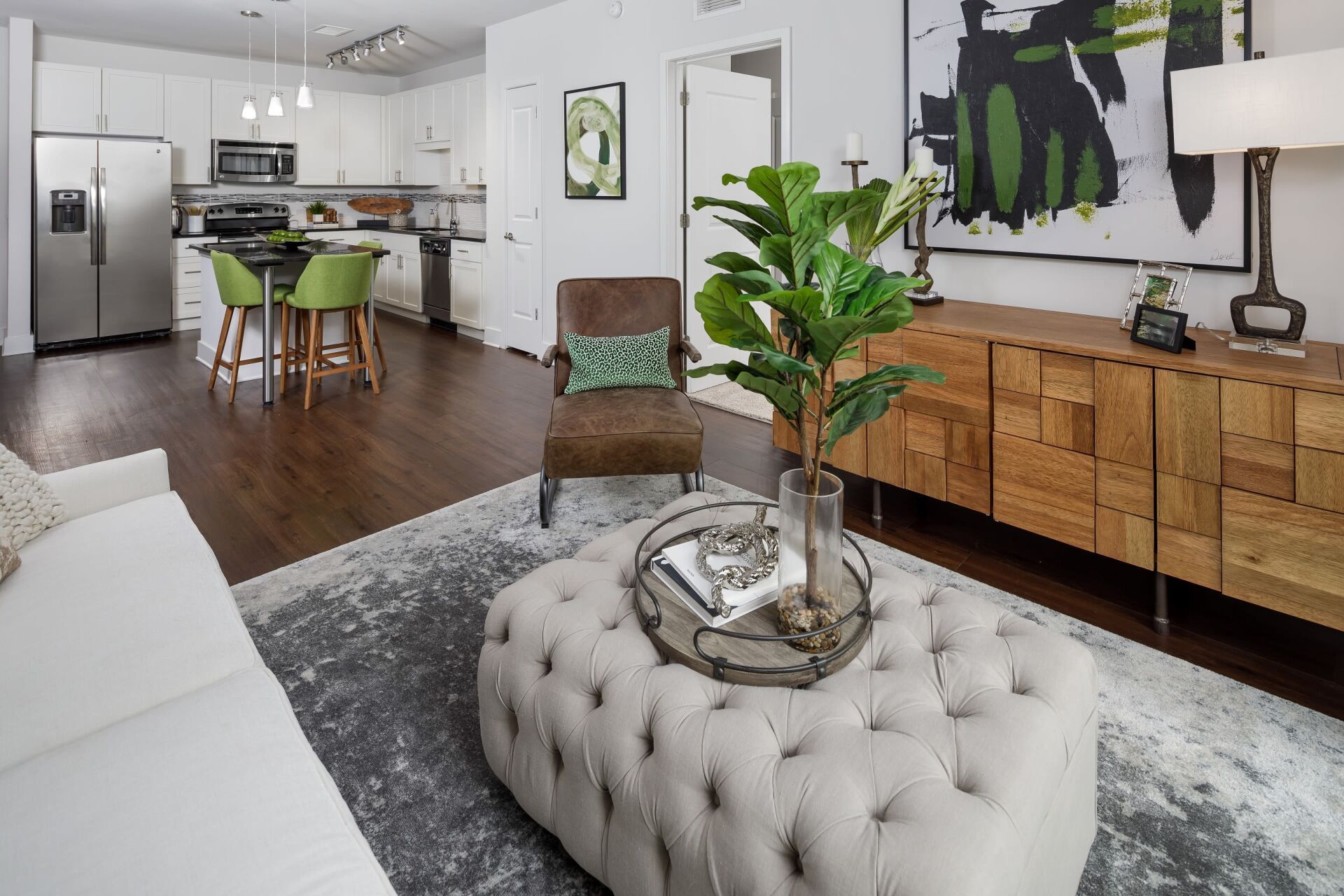 A living room with a couch , chair , coffee table and ottoman.