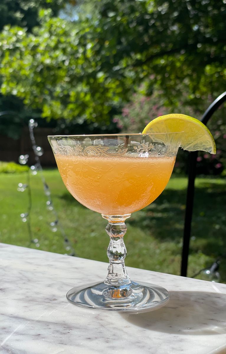 Cocktail in a glass goblet on a table outside