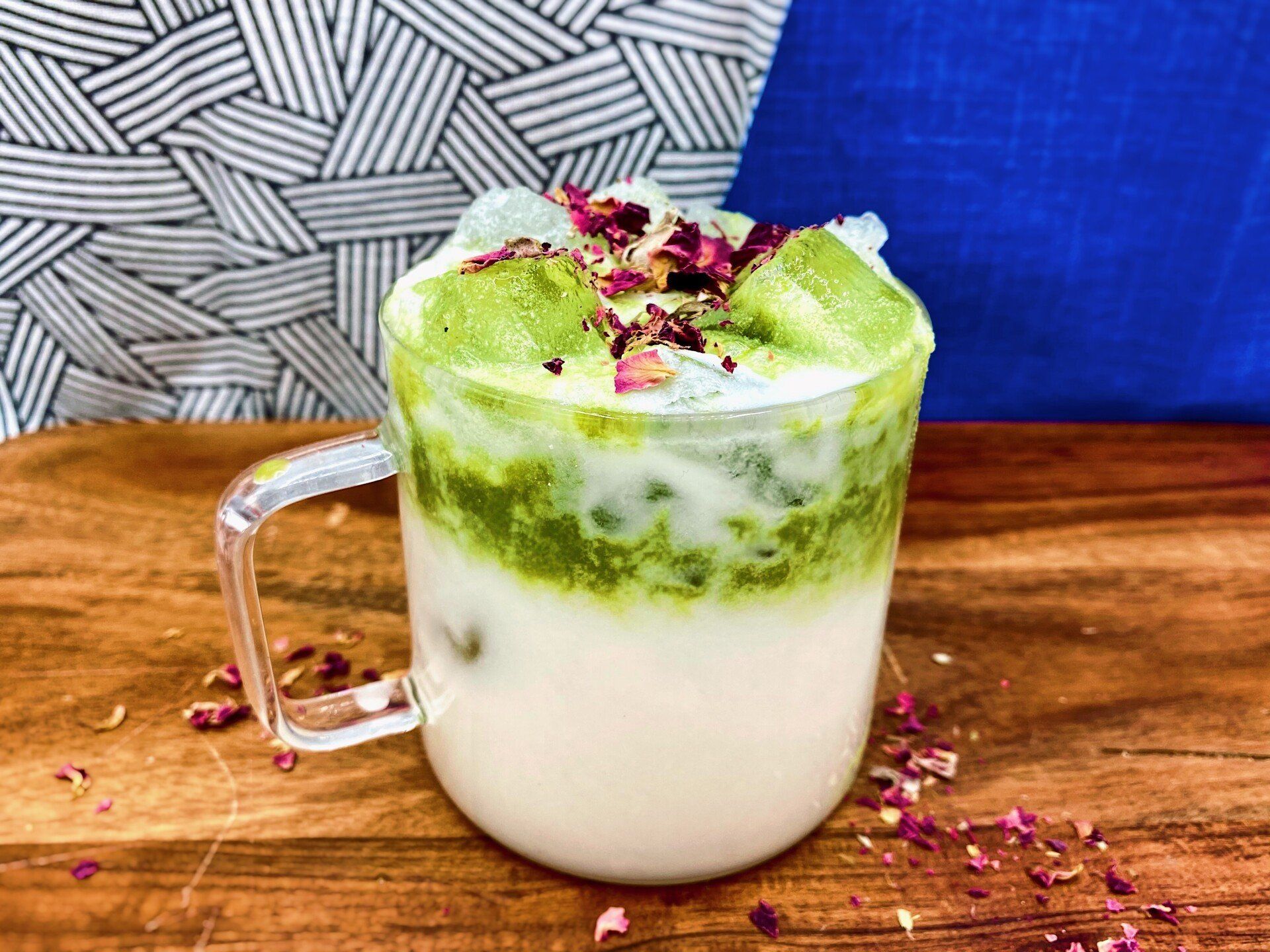 glass mug with white and green cocktail topped with flowers