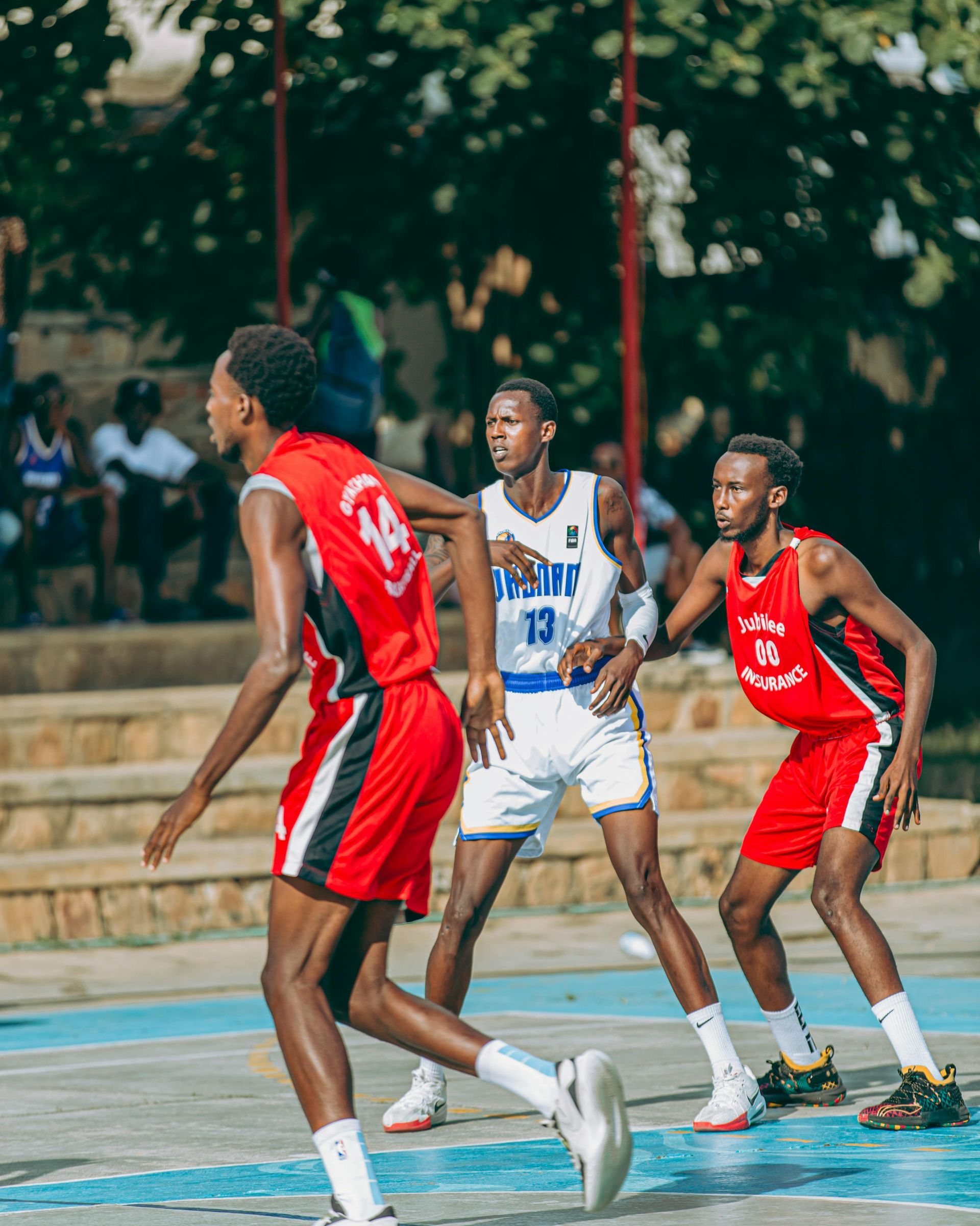 A group of young men are playing basketball on a court.