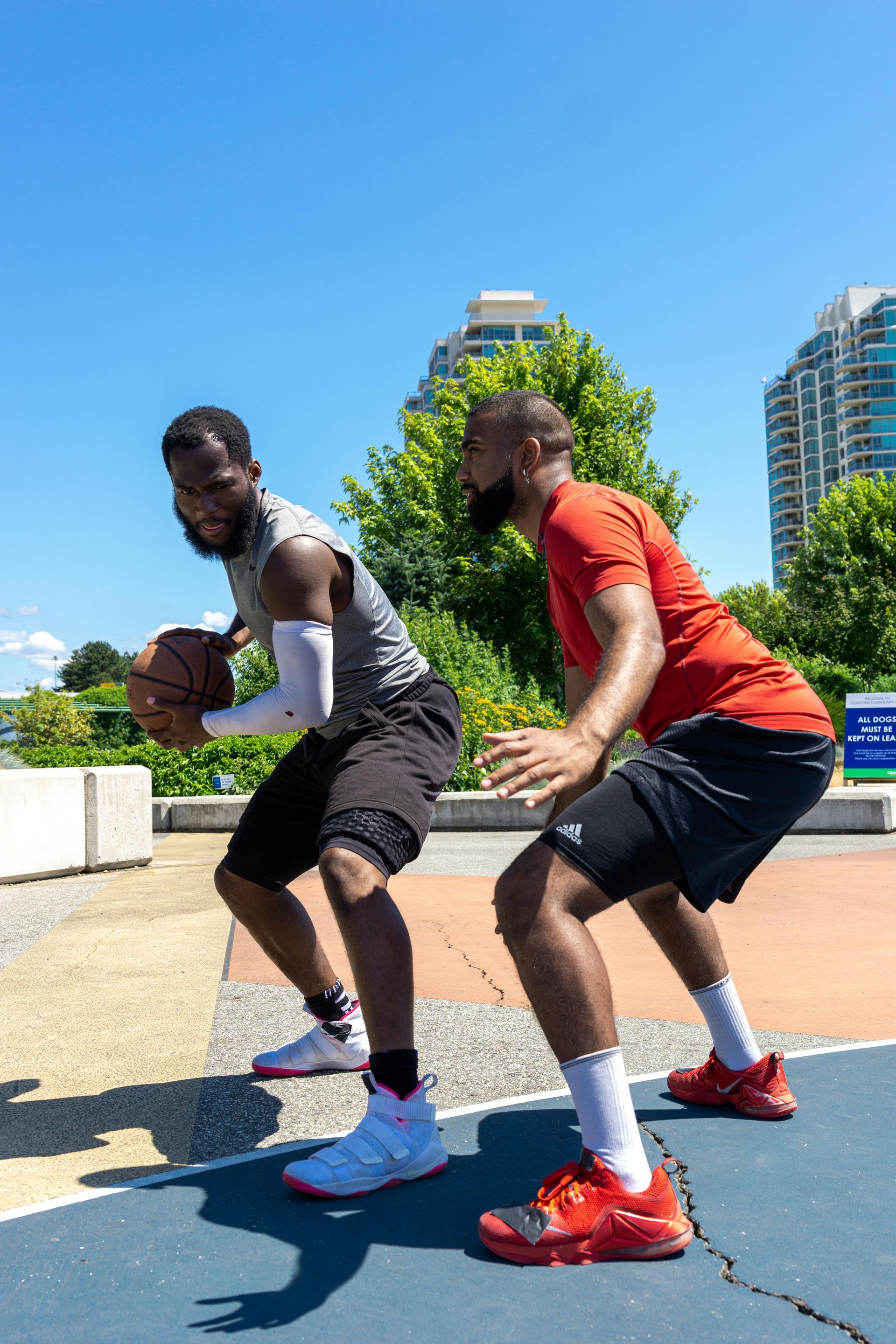 Two men are playing basketball on a court.