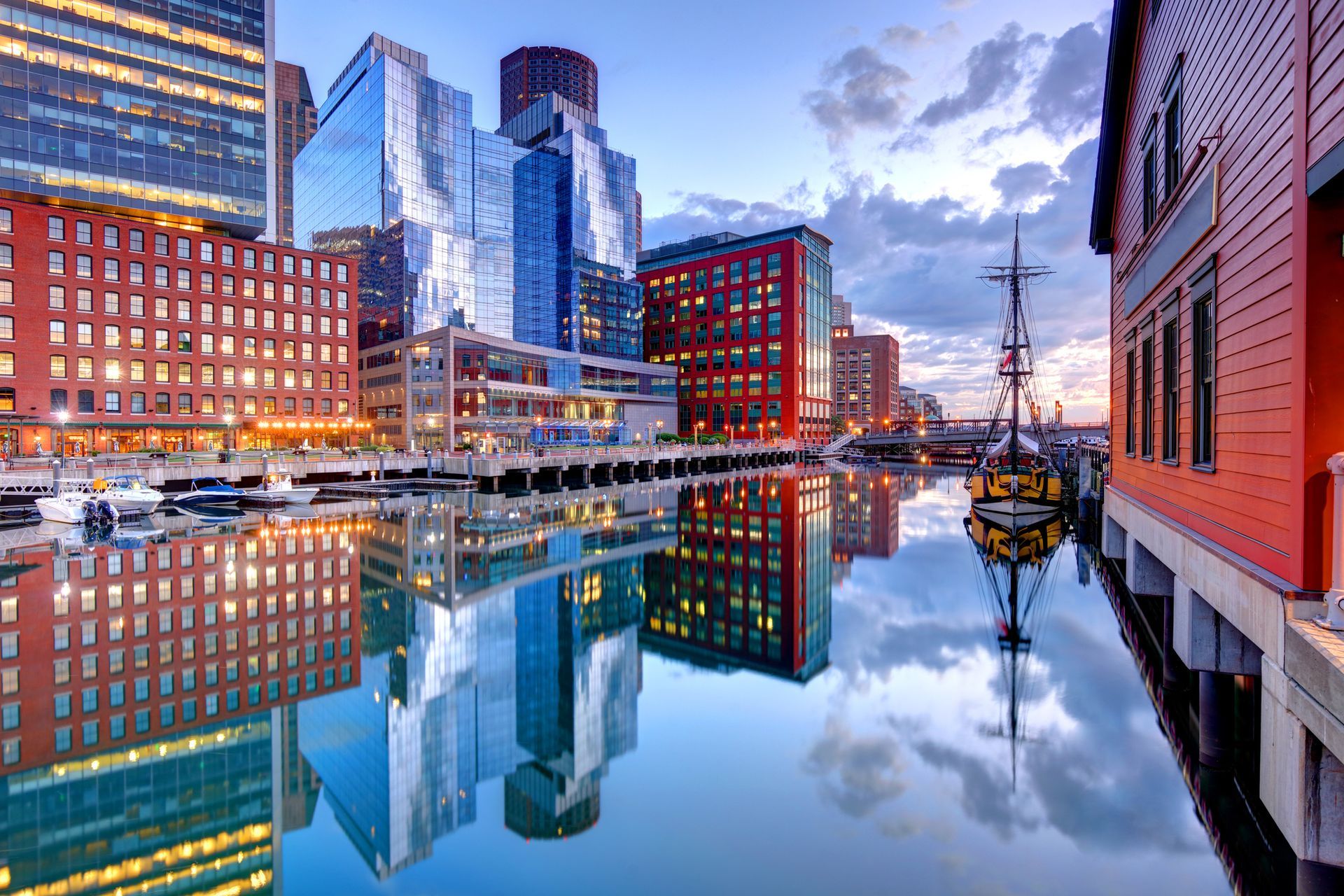 A city skyline is reflected in the water of a harbor. A city skyline is reflected in the water of a harbor.