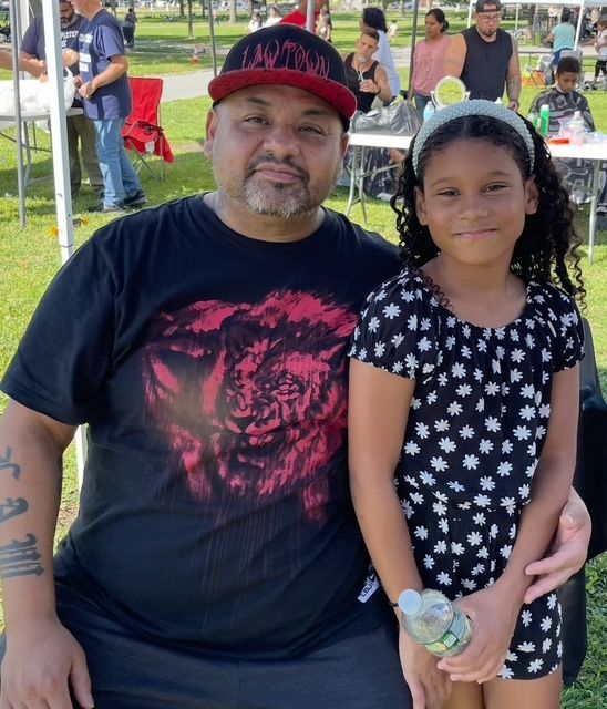 Three men are posing for a picture in front of a lake.