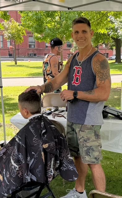 A man with a medal around his neck is playing a game of cornhole
