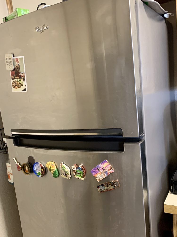 A stainless steel refrigerator with a lot of magnets on it.