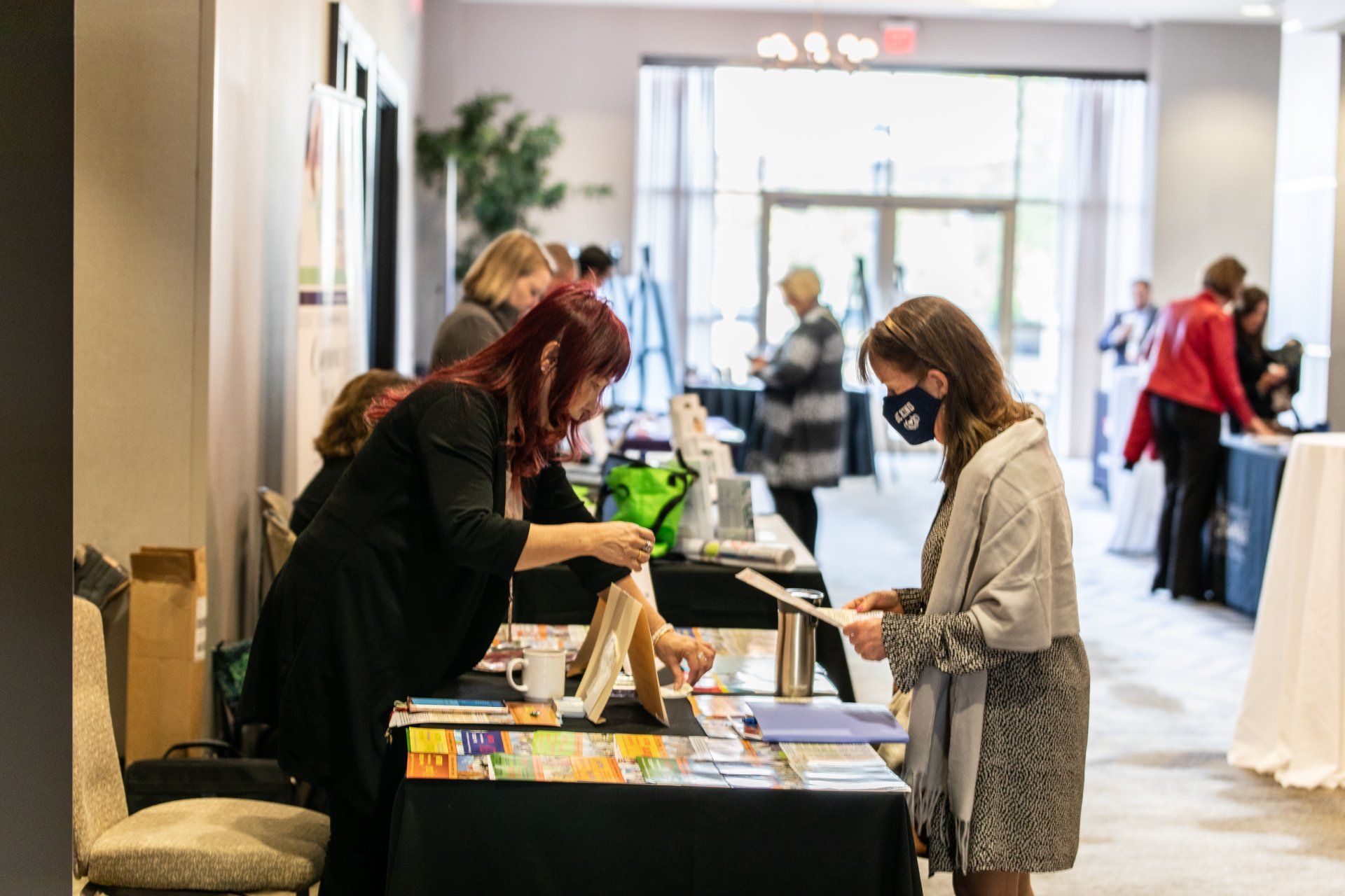 A group of people are standing around a table at a convention.