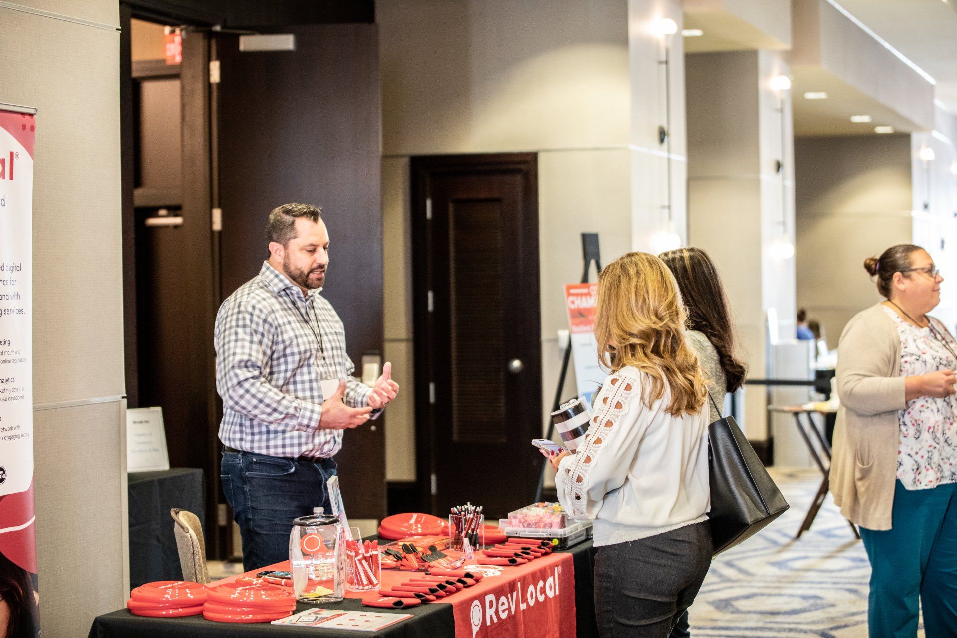 A group of people are standing around a table at a convention.