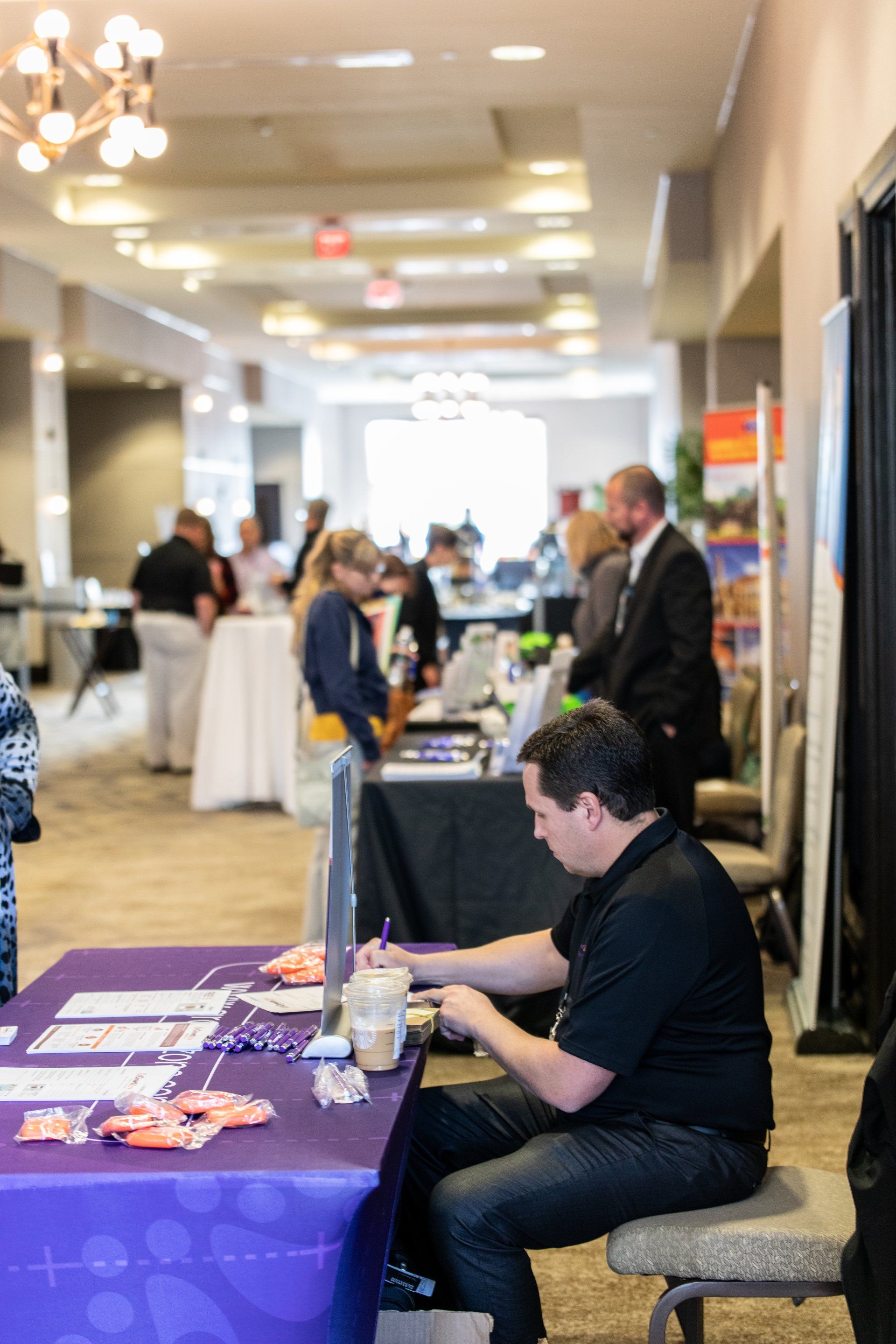 A man is sitting at a table at a job fair.