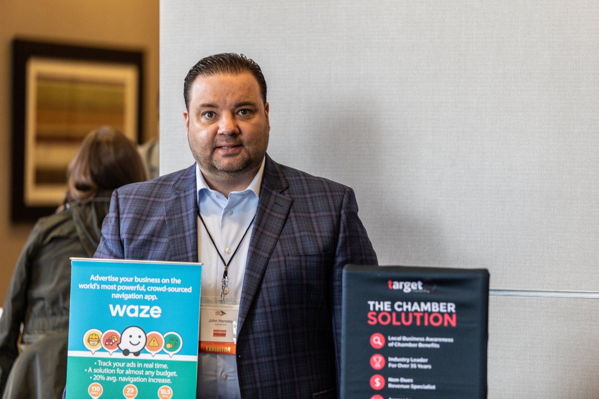 A man in a suit is standing next to a sign that says `` the chamber solution ''.