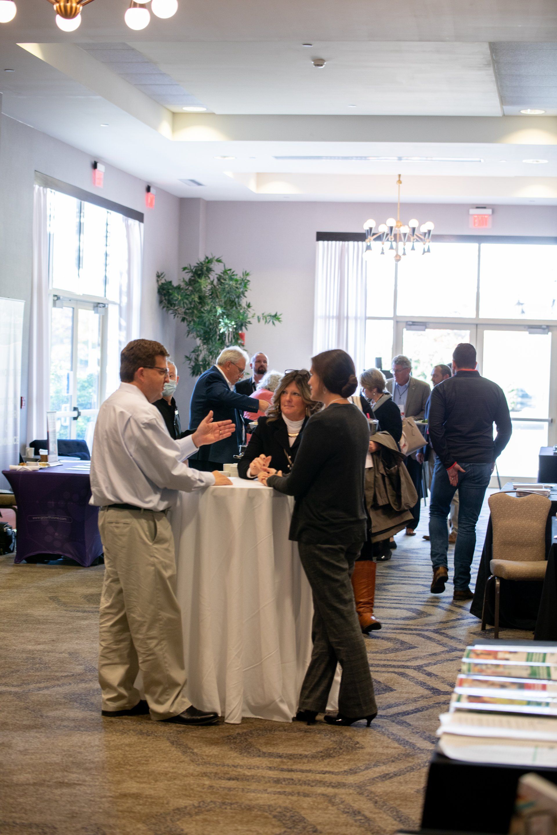 A group of people are standing around a table in a room.
