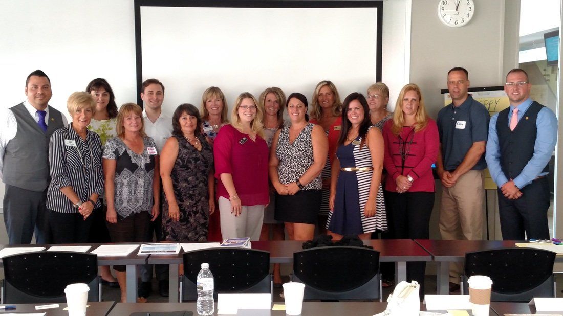 A group of people are posing for a picture in a conference room.