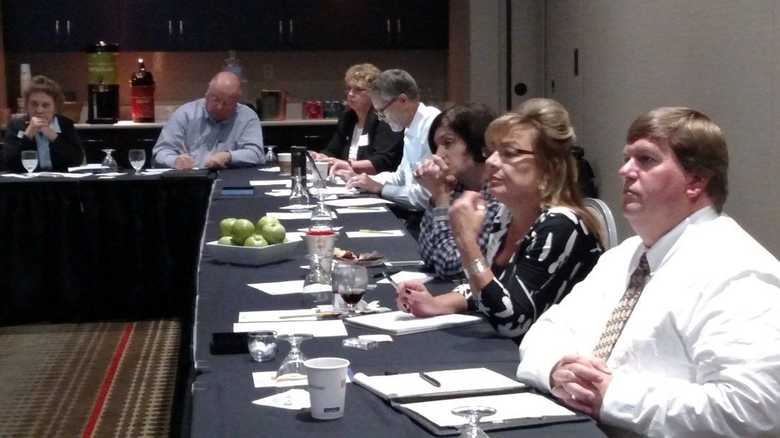A group of people are sitting at a long table