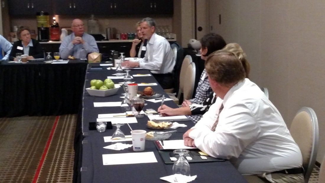 A group of people are sitting around a long table