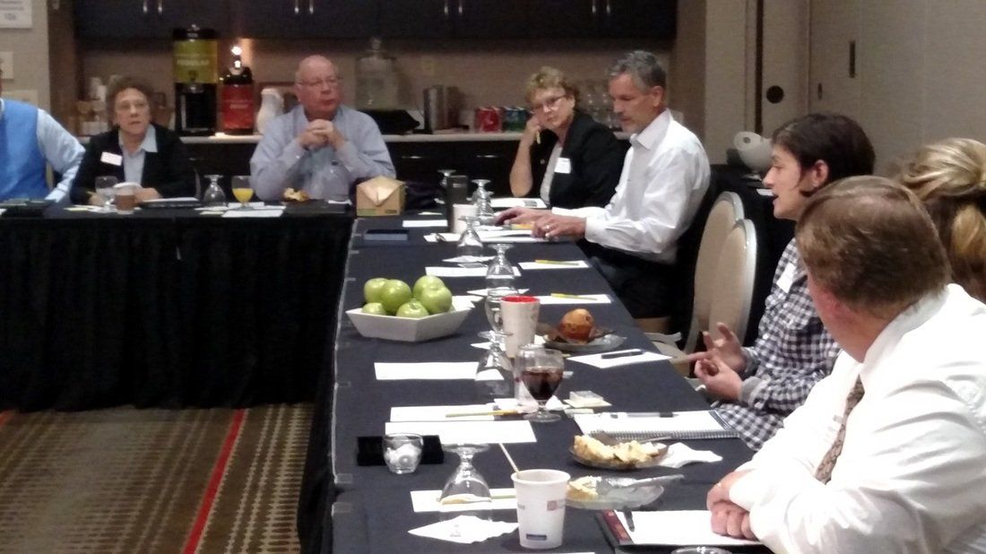 A group of people are sitting around a long table