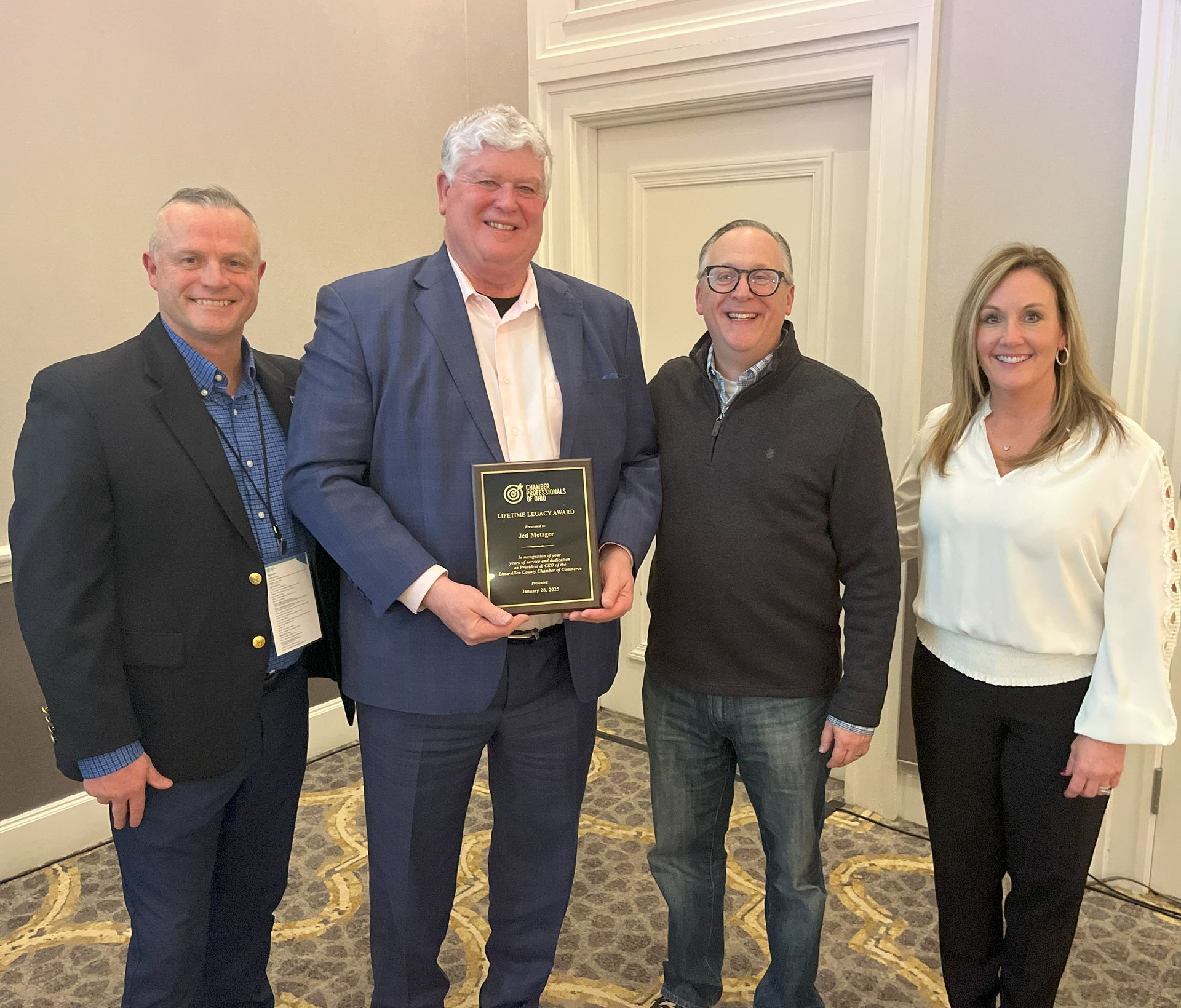 A group of people standing next to each other holding a plaque.