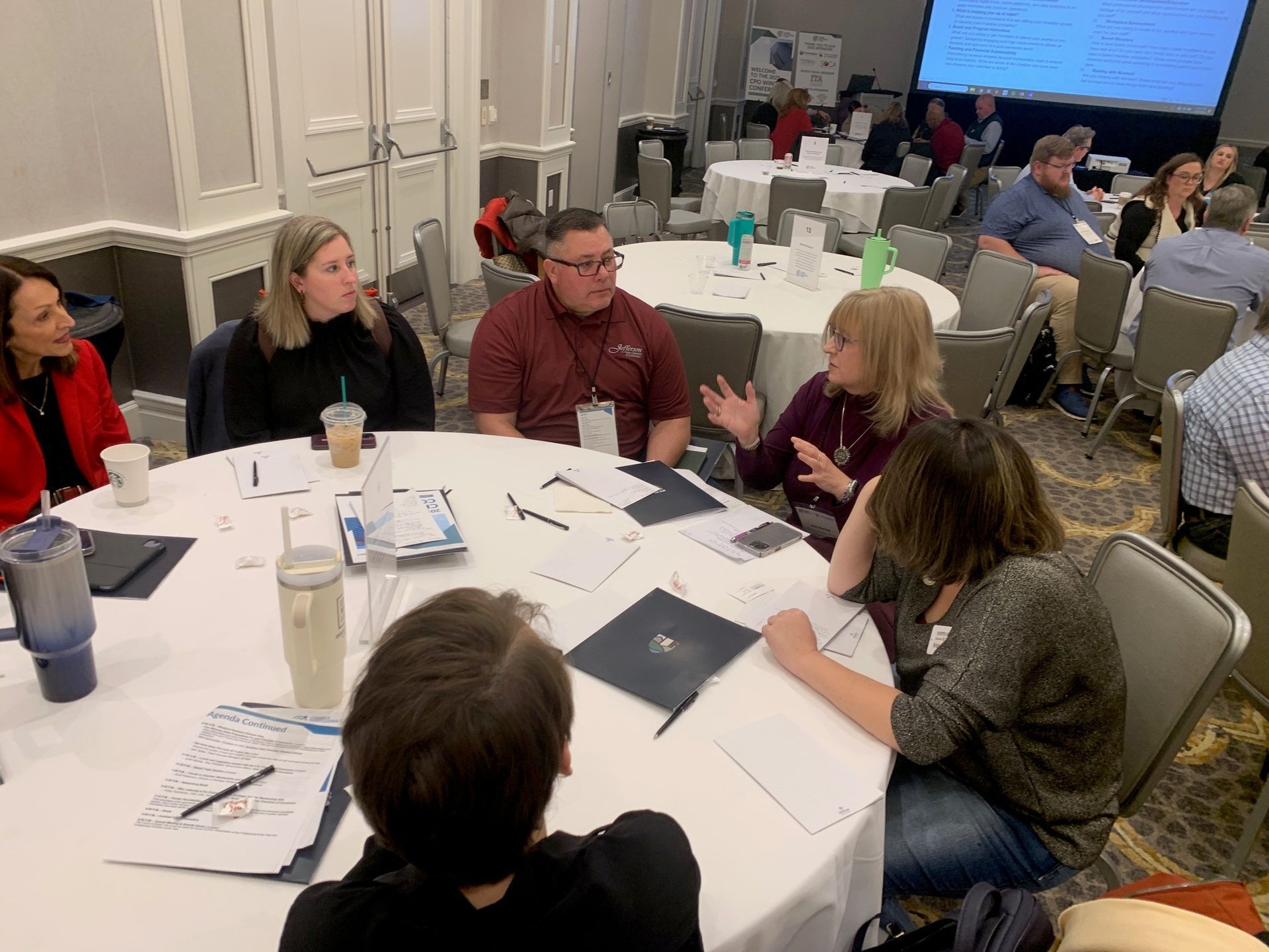 A group of people are sitting around a table in a conference room.