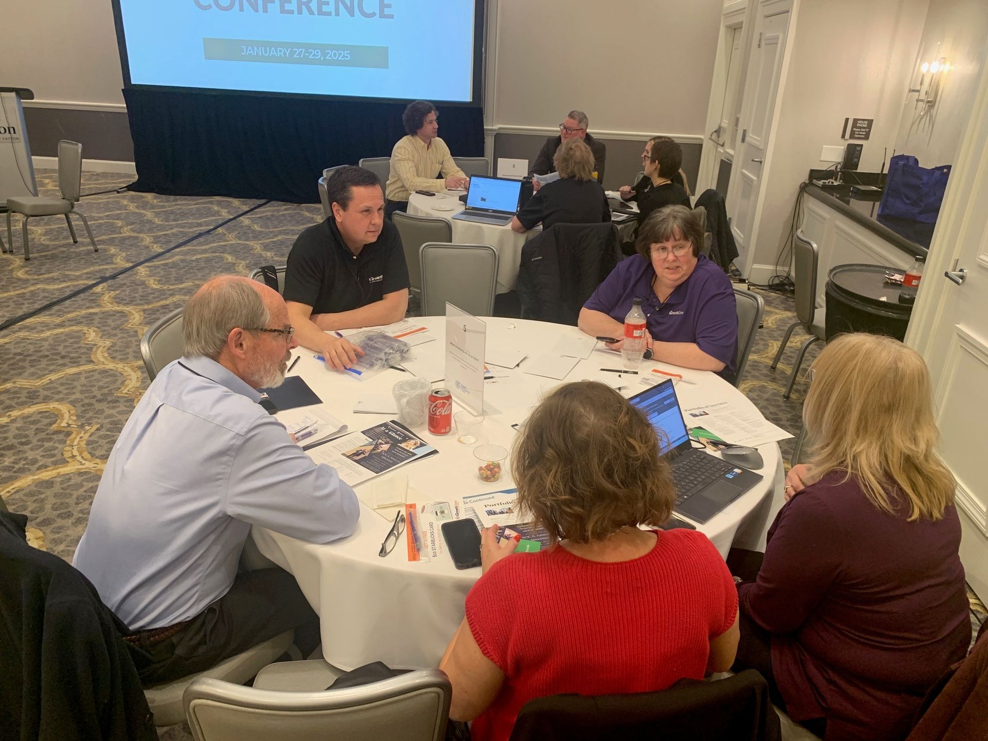 A group of people are sitting around a table in a conference room.
