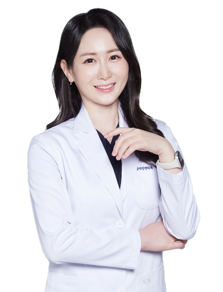 A smiling woman with dark hair in a white lab coat, arms crossed, against a white background.