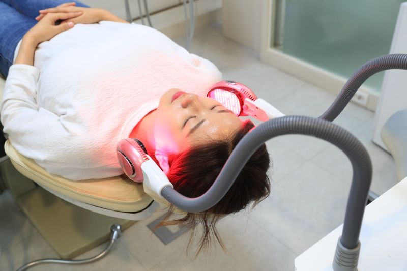 首爾江南診所中女性躺在椅子上接受紅光治療。
