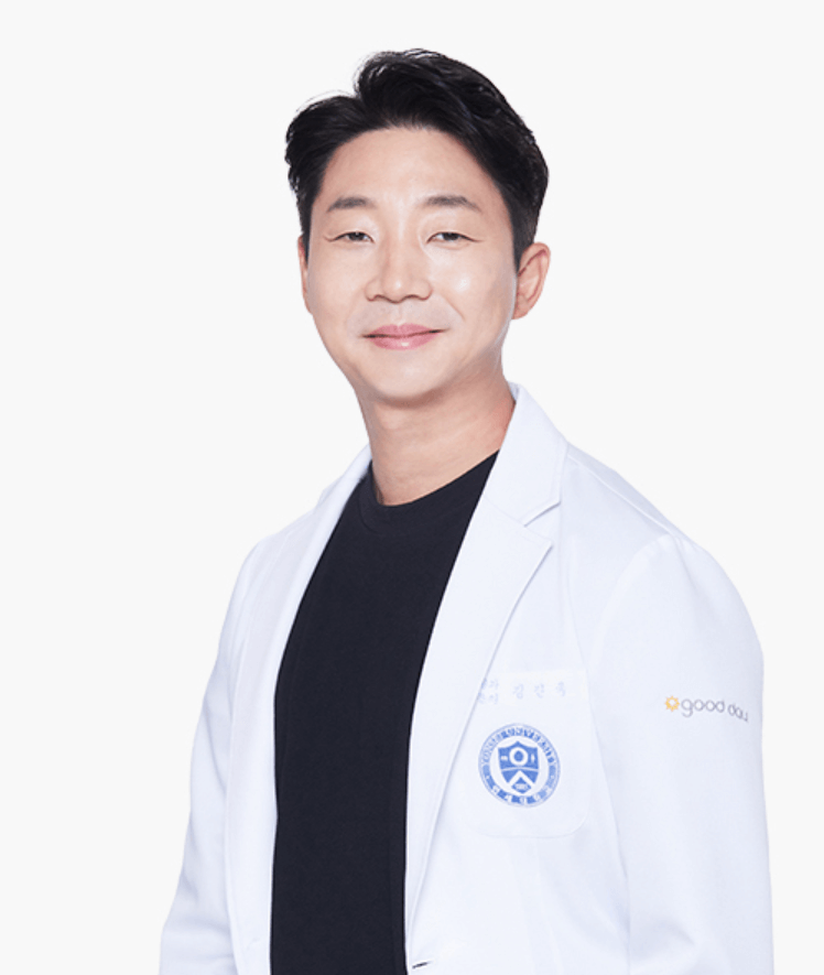 A smiling Asian man in a white lab coat stands against a white background. He's wearing a black shirt and has short, dark hair.