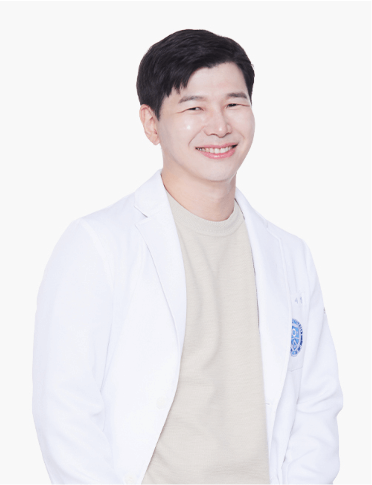 A smiling Asian man in a white lab coat stands against a white background. He's wearing a black shirt and has short, dark hair.