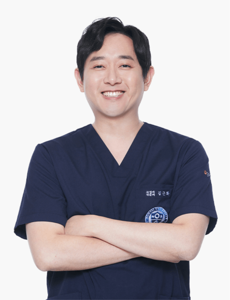 A smiling Asian man in dark blue scrubs with crossed arms. He appears to be in a medical setting.