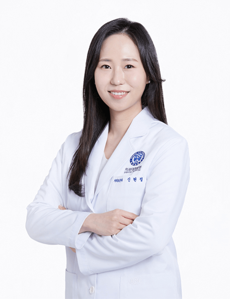 A smiling woman wearing a white lab coat, arms crossed, stands against a white background.