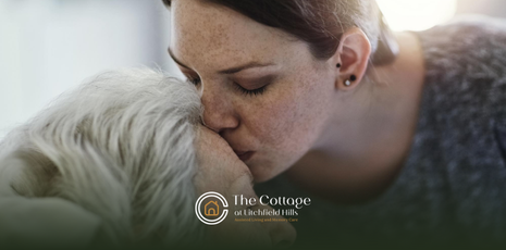 A caregiver gently kissing a senior’s head