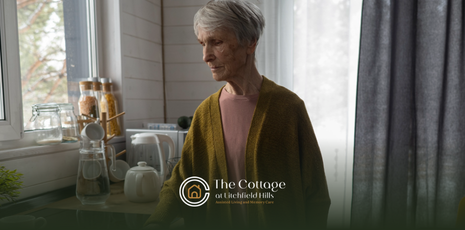 An elderly woman aging in place, standing alone in a kitchen