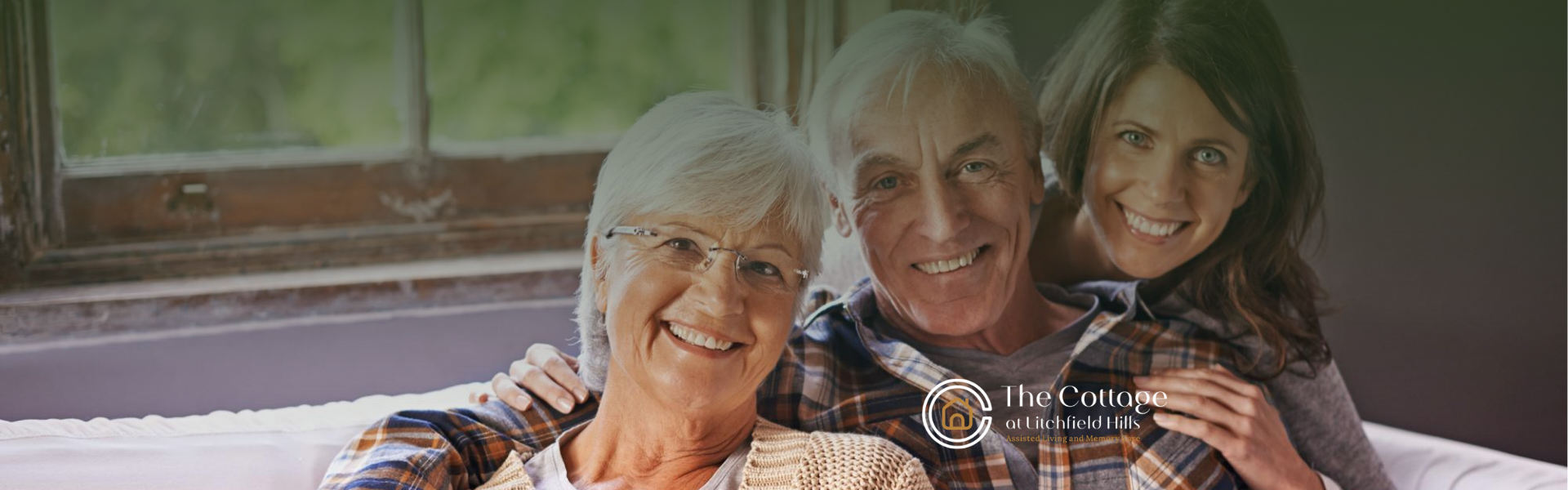 A woman with her senior parents smiling on a couch