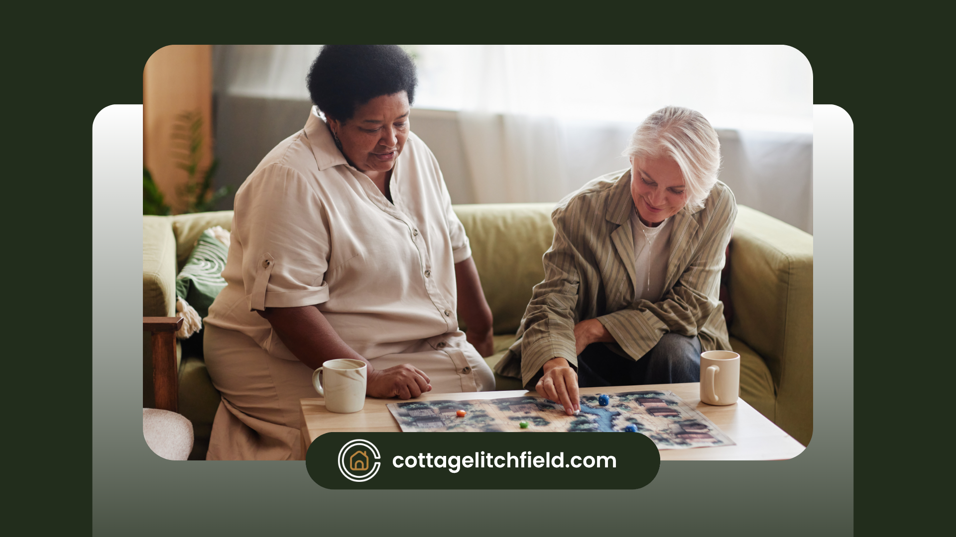 An assisted living caregiver and an older woman are sitting on a couch playing a puzzle.