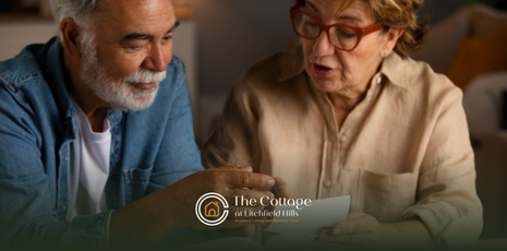 Two elderly people sitting at a table, looking at pictures