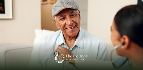 A healthcare professional uses a stethoscope to examine a smiling senior 
