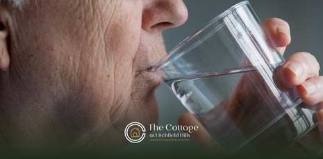 An elderly person drinking a glass of water