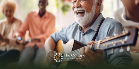 A senior playing a guitar while other seniors singing happily