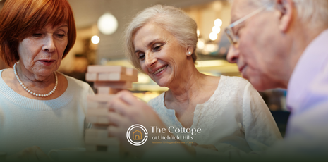 Three older adults playing a game, smiling, indoors.