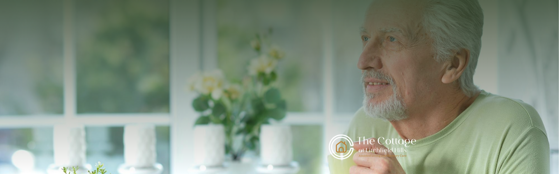 An elderly man sitting on a porch, holding a cup of tea