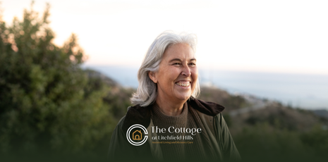 An elderly woman smiling alone, oudoors.