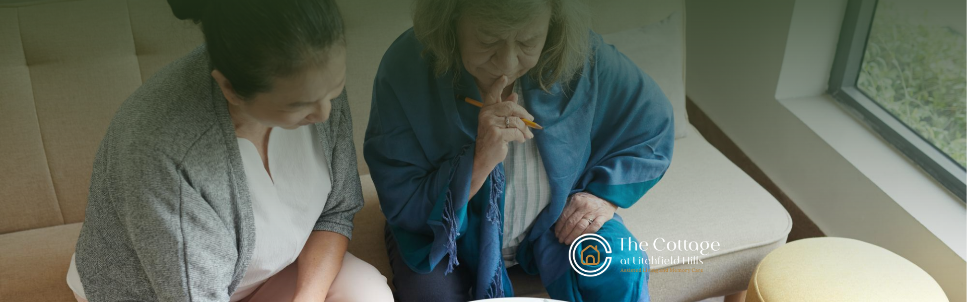 A patient with Alzheimer's and a caregiver answering a puzzle