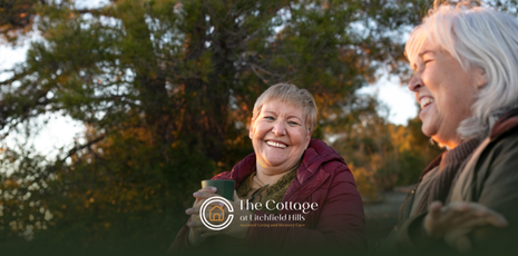 Two smiling elderly people outdoors.