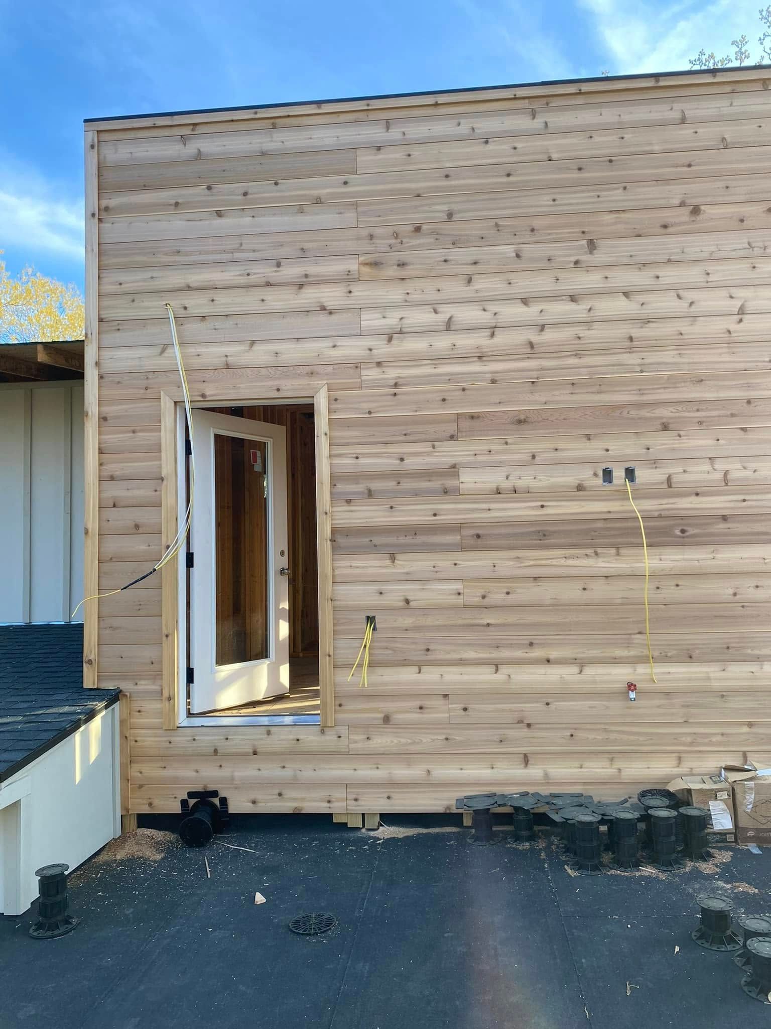 A wooden building with a door that is open