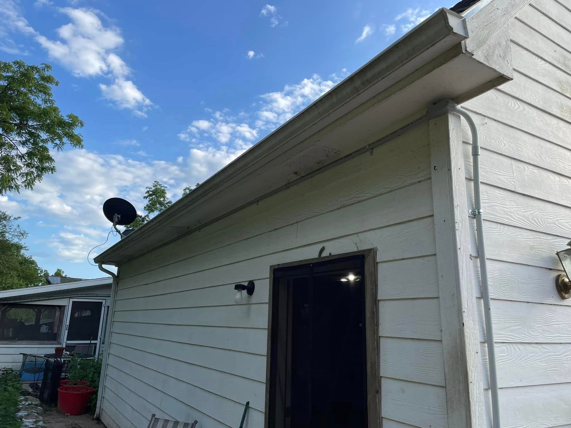 A white house with a satellite dish on the roof.