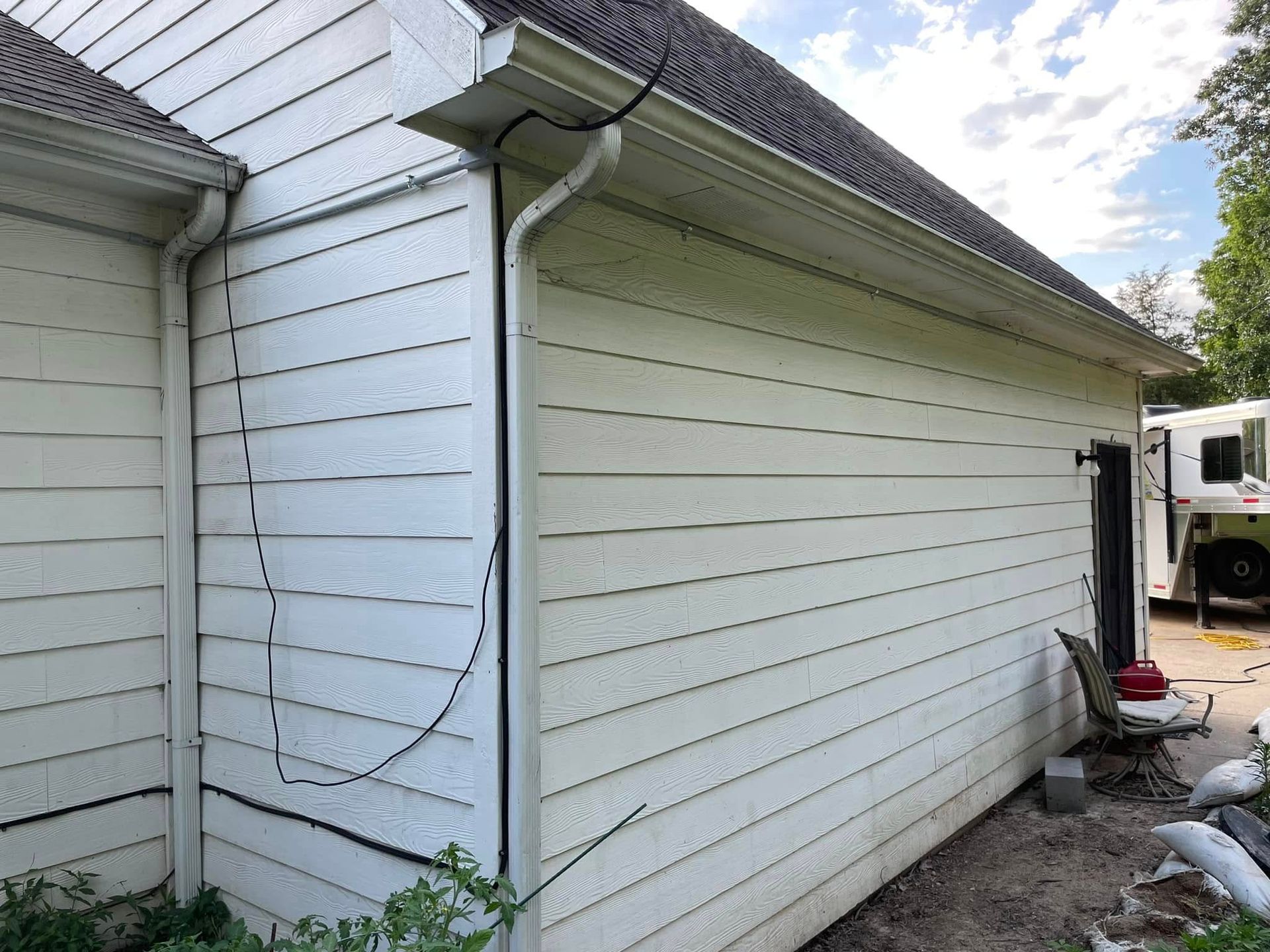 A white house with a truck parked in front of it.